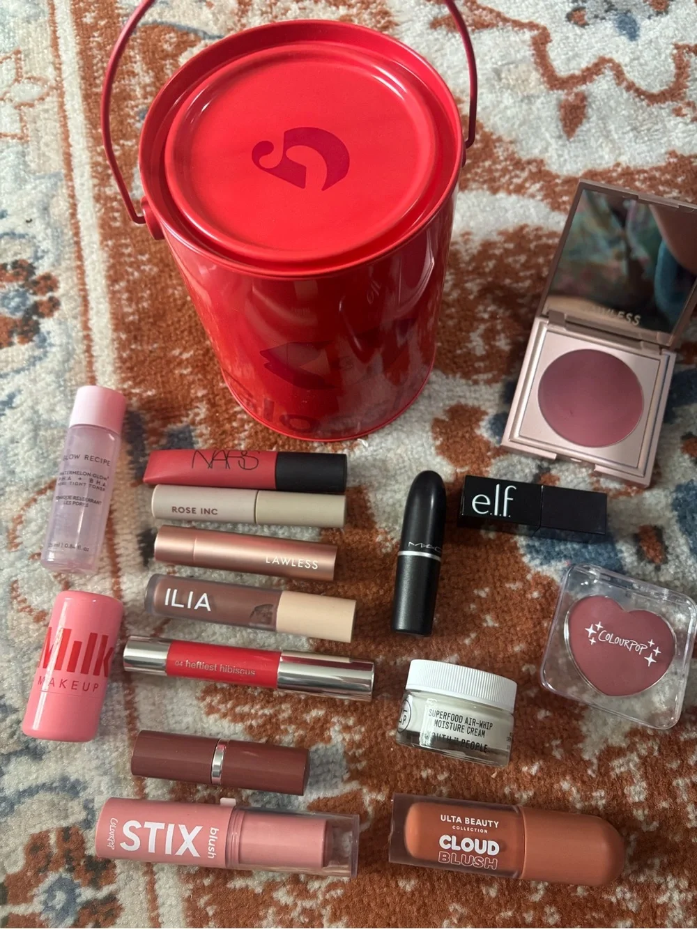 Glossier red mini bucket with mixed pink and mauve lip products